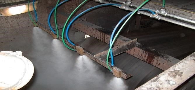 dust-control-for-conveyor-transfer-chutes An image of conveyor with dust suppression spray in operation